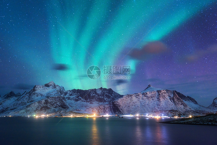 北极光海上,雪山城市灯光夜间挪威洛福滕岛的北极光紫色的星空极地的灯光冬季景观与极光反射水中图片