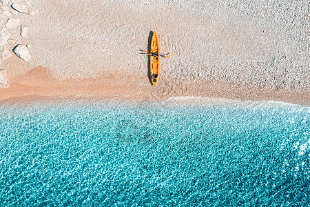 空中观看空沙滩与黄色独木舟,海岸与透明的蓝色水阳光明媚的日子夏天克罗地亚旅行船的顶部视图日落时皮艇的景观图片