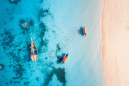 夏天的日落时,清澈的蓝色水中俯瞰渔船桑给巴尔的小船游艇沙滩的无人驾驶飞机上俯瞰旅行热带海景与帆船,海洋图片