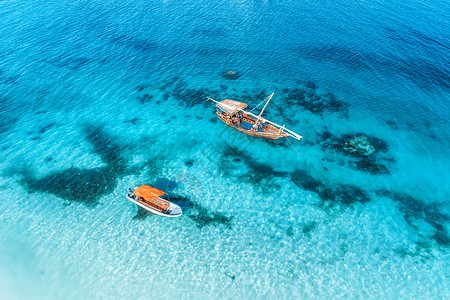 夏天日落时,透明的蓝色水中俯瞰渔船非洲桑给巴尔印度洋漂浮船的无人驾驶飞机上俯瞰清澈的大海里游艇的景观海景图片
