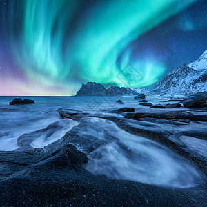 雪山沙滩上的北极光,石头挪威洛福滕岛的北极光极地灯光的星空夜间冬季景观与极光,海洋与模糊的水图片