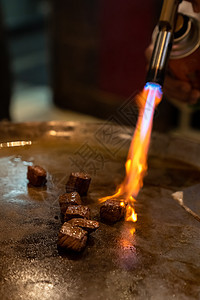 烤牛肉铁板烧食谱日本烤牛肉烹饪锅与刮刀煤气燃烧器火焰背景图片