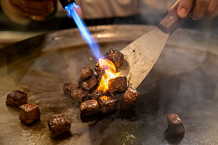 烤牛肉铁板烧食谱日本烤牛肉烹饪锅与刮刀煤气燃烧器火焰图片