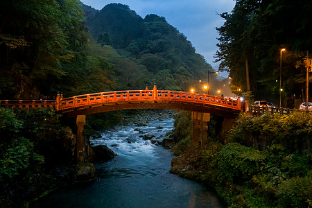 日暮日落时分,日本NikkoTochigi河小溪上的标志红桥图片