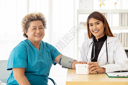 医院诊所检查室测量老妇女血压的女医生图片