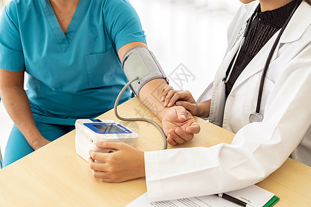 医院诊所检查室测量老妇女血压的女医生图片