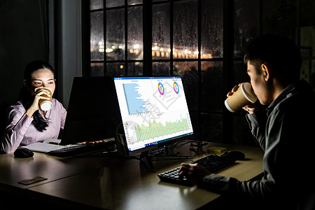 轻的亚洲成商人女人深夜用台式电脑笔记本电脑办公室工作时喝着热咖啡用努力工作工作图片