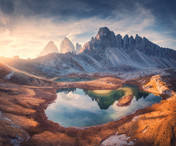 美丽的岩石山湖在日落时丘上水背景图片