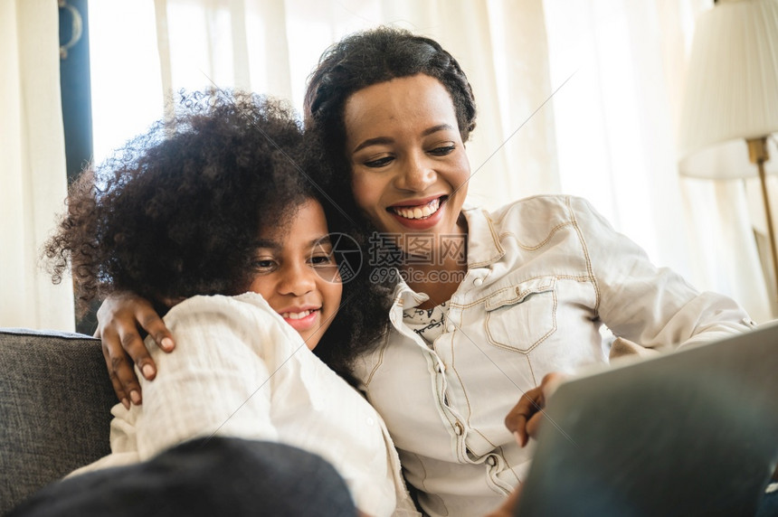 非洲儿童看笔记本电脑在家与母亲一起接受教育图片