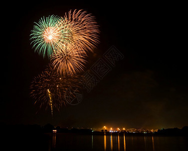 国王生日节和泰在湖边的绿色和橙烟火图片