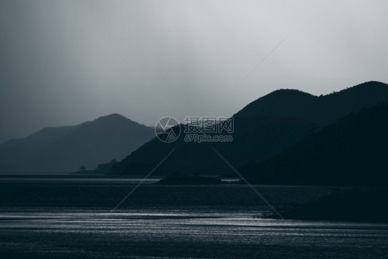 带有湖泊热森林的山地层深色音调图片