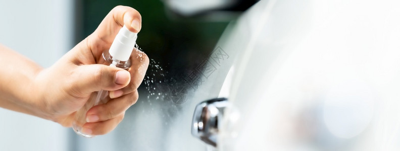 人工喷洒酒精洗车门把手上消毒喷雾以安全防止并保护不受细菌感染图片