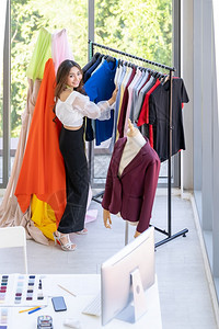 年轻成的亚洲时装设计师在家工作站在衣架或服马身旁穿着多彩姿时尚的衬衫图片