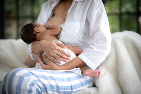 手紧抱着新生婴儿的母亲图片