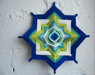 编织艺术在白砖墙背景上用线织装饰曼达拉mandl背景