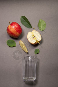 新鲜苹果汁从片流到玻璃杯中图片