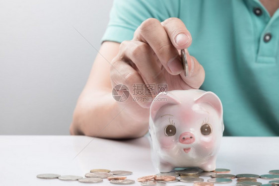 年轻商人在小猪银行存钱图片