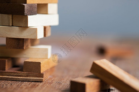 围绕着许多其他区块组成的结构空白木板块其中若干仍然分散在纸质的锈制木桌子上休闲游戏或开业的概念图片