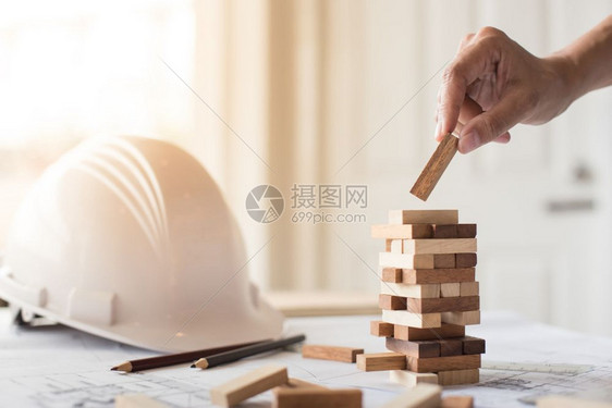 商业人和工程师在塔上设木块的计划图片