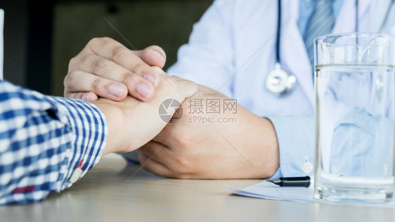 男医生手握病人的手安慰帮助病人图片