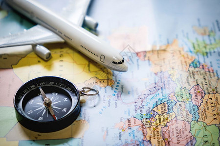 迷你旅游者选择地关注图上的指南针带有塑料玩具飞机旅行概念图片
