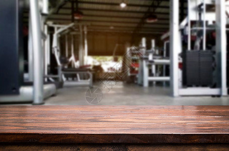 现代俱乐部内健身房背景模糊的木板桌配有设备用于照相或产品展示图片