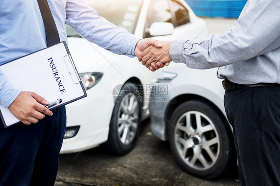 客户在同意保险条款后与汽车保险代理人握手图片