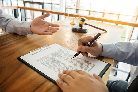 讨论坐在桌面上合同文件的商人和律师法咨询服务的概念图片