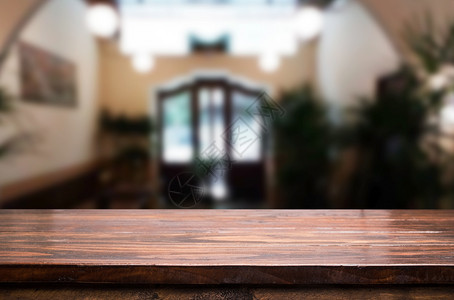 棕色木制桌和咖啡店或餐馆背景模糊带有bokeh图像用于相片补装或产品显示背景图片