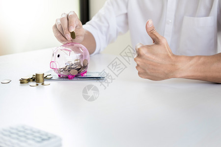 卡通手商人把硬币放进小猪银行储蓄和投资概念背景