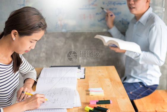 妇女学习并教女师概念育互相帮助坐在教室的桌椅上图片