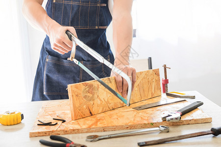 木匠仔细研究工程在工作场所切割木板图片