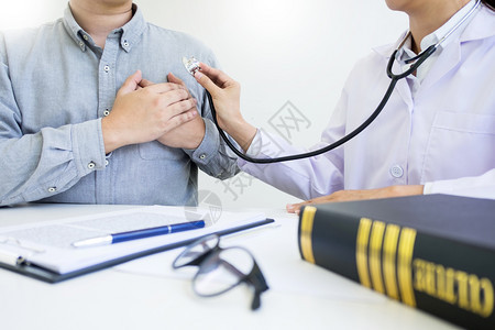 男患者看医生和的qruo办公室听取在医疗办公室用听诊器检查病人胸部图片