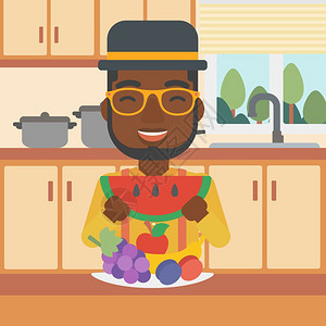 厨房里站在餐桌水果拼盘前的非裔男子图片