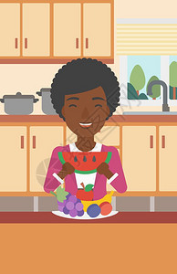 站在餐桌水果拼盘前吃西瓜的非裔女子图片