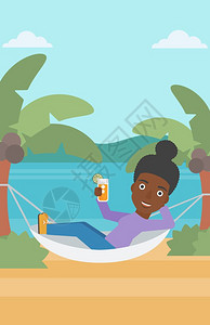 一位在海滩的吊床里休息的非裔女子图片