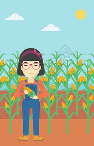 一名站在玉米田里抱着玉米的女性农民图片
