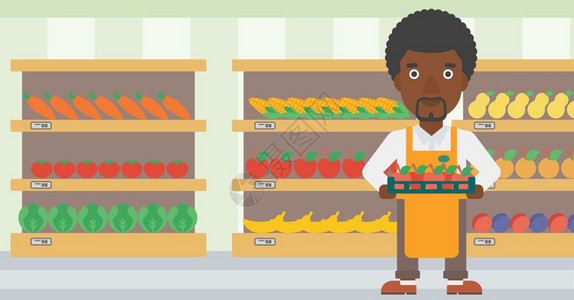 一名在超市货架旁端着一盘苹果的非裔员工图片