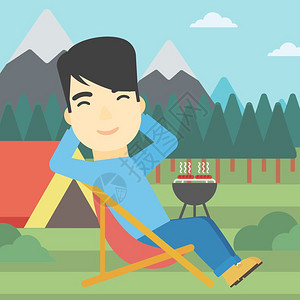 一名坐在营地折叠椅上的亚裔男子 图片
