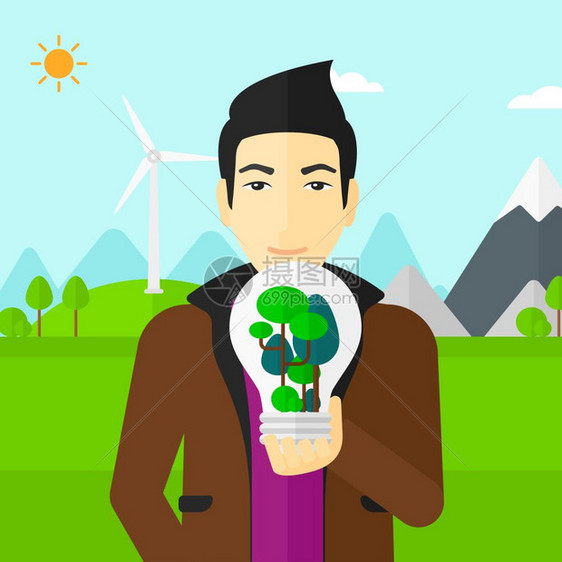 风力发电厂旁手握绿色概念灯泡的男子图片
