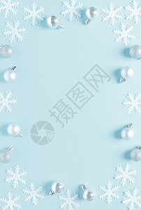 圣诞节新年或节假日冬季庆贺卡装饰球和蓝底雪花的框平地构成顶视图文字空间背景图片