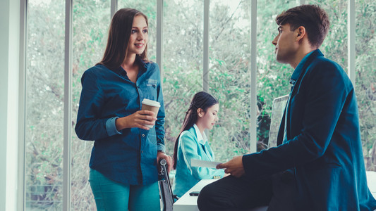 电脑聊天框在现代办公室交谈的男女背景