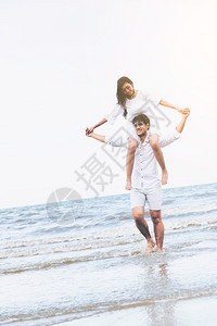 海边情侣女生骑在男生肩上背景图片