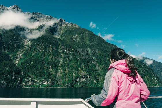 在甲板上观看新西兰南部岛屿风景的女旅行者图片