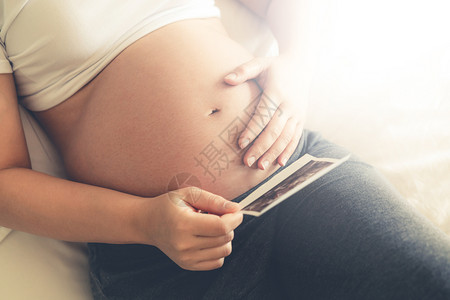 年轻孕妇在怀期间在看四维照片图片