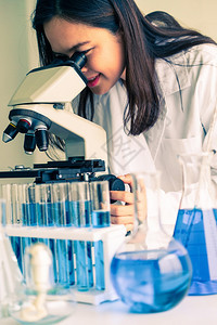 在实验室工作并检查试管生物化学样本的女科家技术研究和发展概念图片