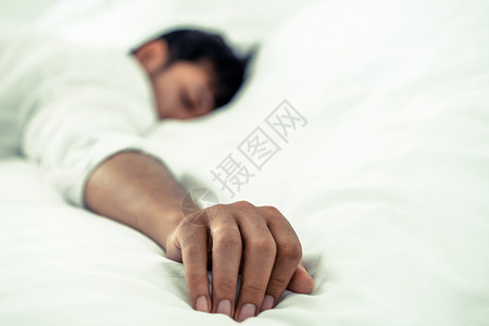 青年男子睡在卧室的床上图片