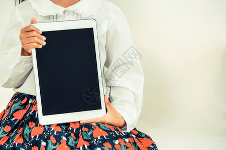 小女孩用白色背景显示平板电脑的黑屏图片