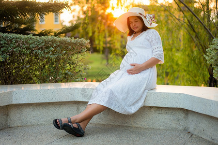 怀孕妇女对在花园之家的新生活感到快乐同时照顾孩子年轻孕妇在怀期间有婴儿产妇前护理和女怀孕概念图片