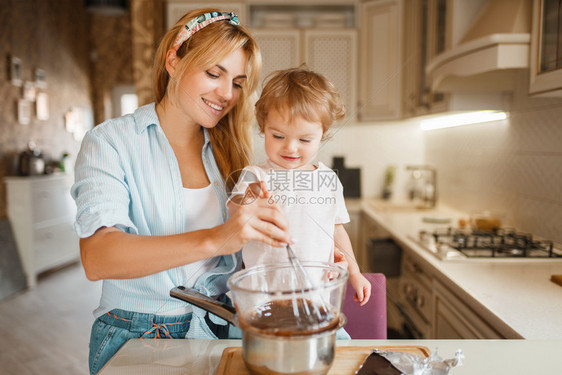 可爱的女人和小孩在厨房做饭幸福的家庭在柜台准备甜点图片